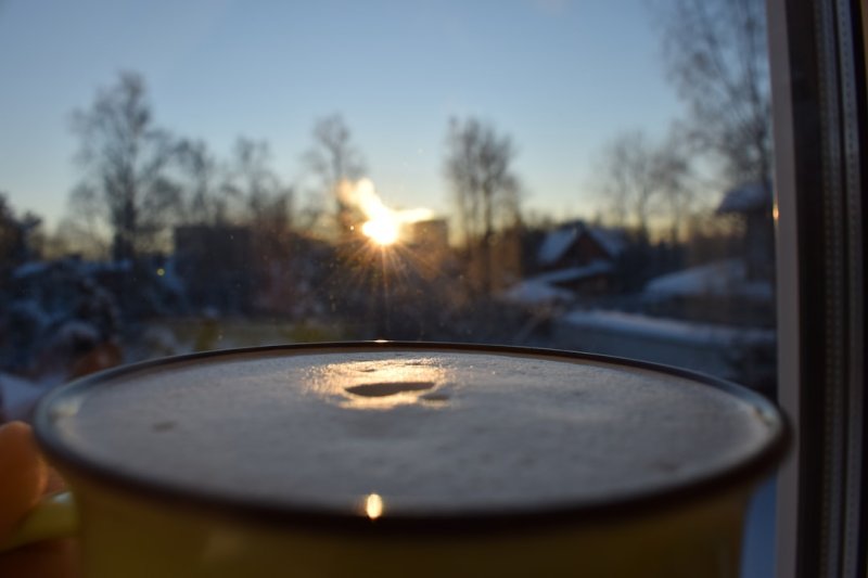 a close up of a cup of coffee in front of a window