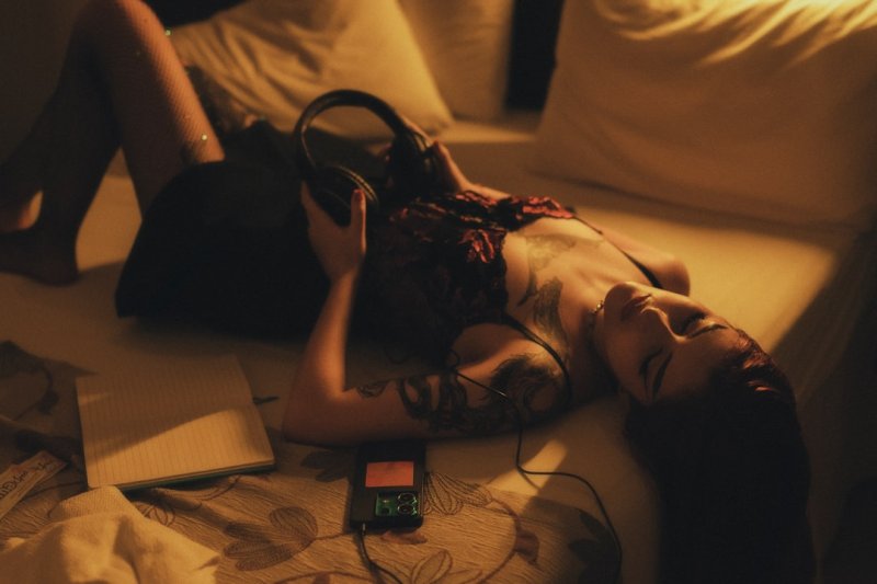 A woman laying on a bed with a cell phone