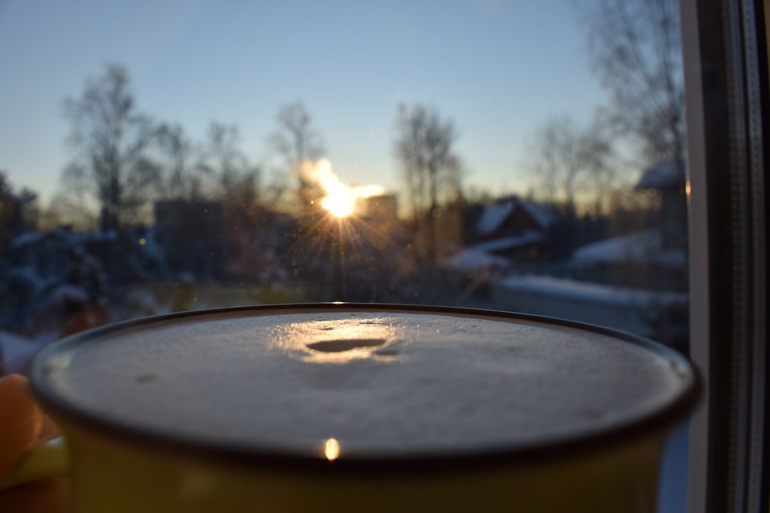 a close up of a cup of coffee in front of a window